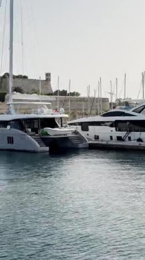 Malta, Valletta - 23 Mart 2025: Güney Avrupa, körfezdeki yat manzarası, eski kasaba ve yat limanı, körfez manzaralı dikey video.