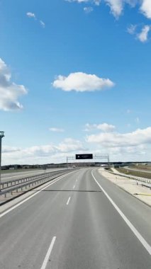 Varşova, Polonya - 25 Nisan 2025: Dikey video, Ulaşım lojistiği, otoyolun otoyol manzarası, arabalar ve kargo kamyonları trafiği, birinci şahıs görüşü.