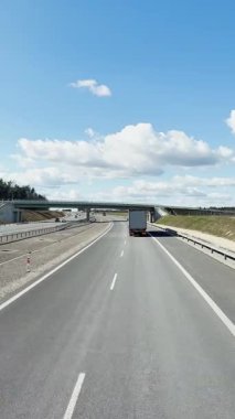 Varşova, Polonya - 25 Nisan 2025: Ulaşım lojistiği, otoyolun otomobil, araba ve kargo kamyonları trafiğine bakış açısı, Dikey video birinci şahıs görüntüsü.