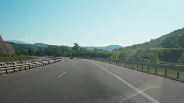 Yavaş yol gezisi, hareket halindeki bir arabadan birinci şahıs manzarası yaz doğal manzarası, tepe arazisi, yolda araba yolculuğu..