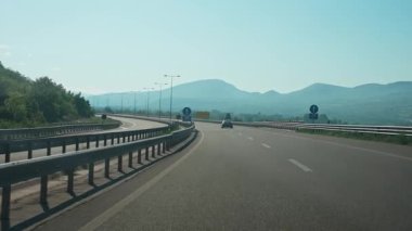 Yavaş yol gezisi, hareket halindeki bir arabadan birinci şahıs manzarası yaz doğal manzarası, tepe arazisi, yolda araba yolculuğu..