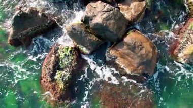 Deniz manzarası, kayalık kıyı şeridi, denizdeki taşların ilk görüntüsü, taşlar ve kayalar, dokular video arka plan..