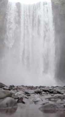 İzlanda manzarası, çirkin, büyük şelalenin birinci şahıs görüntüsü, İzlanda doğası, dinginlik şelale manzarası, kayalık arazi arka planı, eriyen buzullar ve akan su akışı..