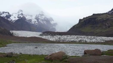 İzlanda arka planı, buzul vadisi manzarası, kuzey manzarası, İzlanda 'nın güzel manzarası ve yeşil toprak dokusu, ufuktaki dağlar, sallanan kamera..