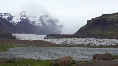 İzlanda arka planı, buzul vadisi manzarası, kuzey manzarası, İzlanda 'nın güzel manzarası ve yeşil toprak dokusu, ufuktaki dağlar, sallanan kamera..