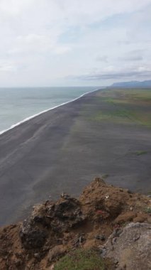 İzlanda açık hava, yükseklikten dikey manzara, okyanus manzarası ve büyük kıyı alanı, karanlık kum ve toprak dokusu, kıyı doğa arka planı..