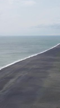 İzlanda açık hava, yükseklikten dikey manzara, okyanus manzarası ve büyük kıyı alanı, karanlık kum ve toprak dokusu, kıyı doğa arka planı..