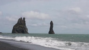 Açık hava, İzlanda manzarası, okyanus manzarası ve ufuktaki görkemli uçurumlar, büyük kıyı bölgesi manzarası, toprak dokusu, koyu kum, kıyı doğası arka planı, kamera titremesi..