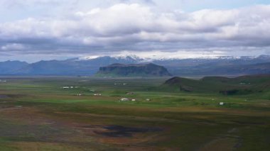 İzlanda, büyük dağ vadisi manzarası yükseklikten, İzlanda doğasının güzel dinginliği ve yeşil toprak dokusu, panoramik doğa arka planı.