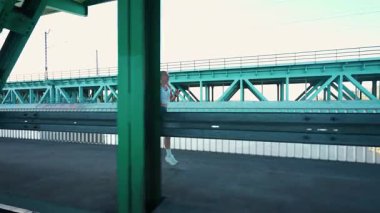 Varşova, Polonya - 20 Eylül 2025: Sabah koşusu, nehrin üzerindeki köprüde koşan sporcu kadın, yarı maraton antrenmanında profesyonel koşucu.