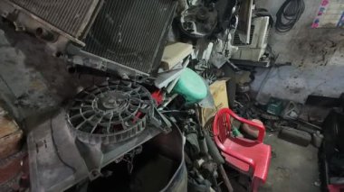 Karışık bir garajda kullanılmış araba parçaları yığını.