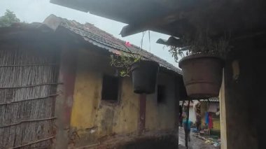 Muson sırasında Maharashtra 'nın sakin kırsal bir köyünde, yemyeşil ve doğa ile çevrili geleneksel kulübeler var..