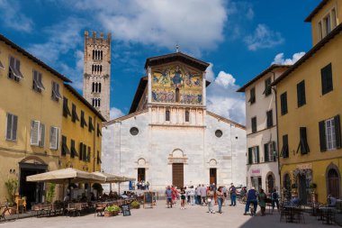 Lucca, İtalya, 7 Haziran 2023 Lucca 'yı gezmek. Şehir tarihi merkezinde Aziz Fredianus Bazilikası 'nı ziyaret eden turistler