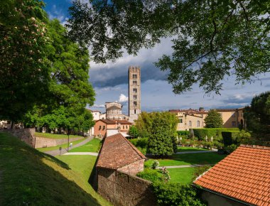 Lucca, ITALY, 15 Mayıs 2023 - Lucca tarihi kent simgesi: Şehir duvarları parkı, St Fredianus Kilisesi, Guinigi Kulesi ve Pfanner Bahçesi