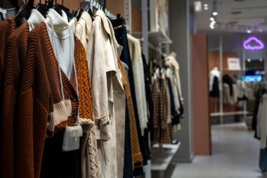 Mağazadaki askılarda asılı bir grup kadın giysisi..