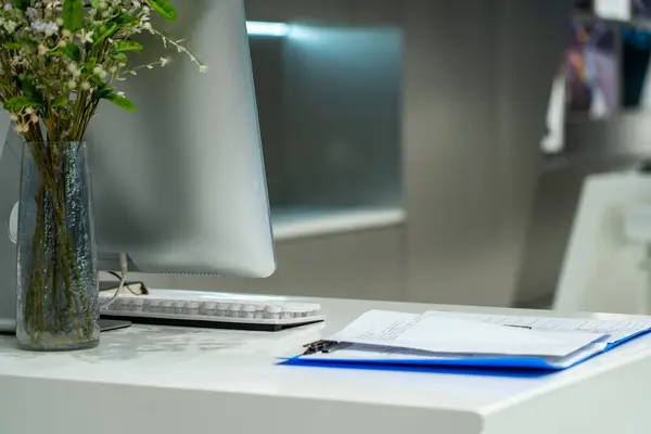 Bilgisayarlı modern ofis masası ve beyaz masadaki belgeler.