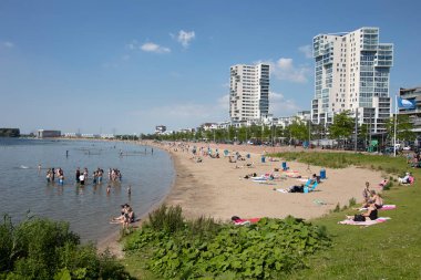 Rotterdam, Hollanda - 24 Haziran 2024: İnsanlar Rotterdam Nesselande 'deki Zevenhuizerplas gölünde güneşleniyor ve dinleniyorlar