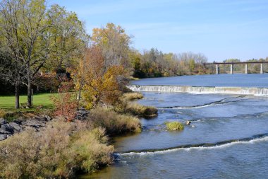 Sonbahar güneşli küçük bir kasabada nehir manzaralı bir park yeri.