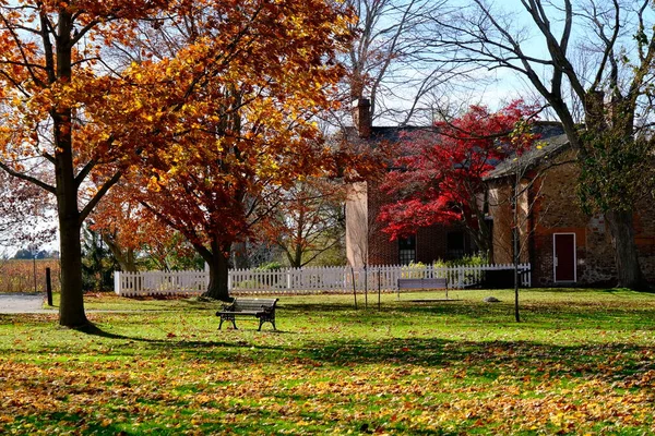 秋末的时候 公园里的长椅在房子前面 — 图库照片