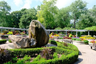 Yazın bahçesinde büyük taşlar ve banklar.