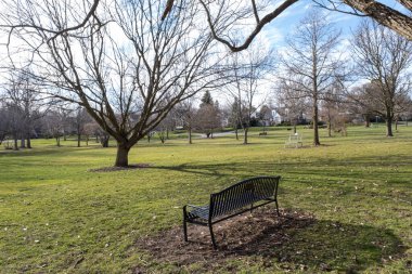 Bahar parkında küçük bir bankta.