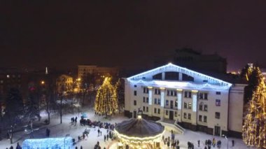 Tiyatronun arka tarafı mahvoldu ve Mariupol Yeni Yıl 2019 'da Atlıkarınca şehrin güzel dekorasyonları. Geceleri kar altında huzurlu bir şehir. Parlak ışıklar.