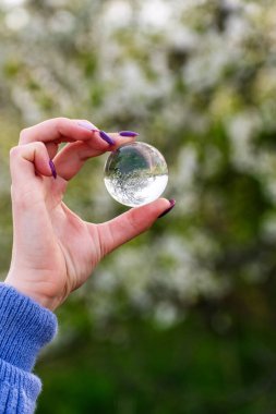 Bir el cam bir katmanı tutar. Bu da dünyanın altını üstüne getiriyor. Işık kristal küreye nasıl yansıyor.