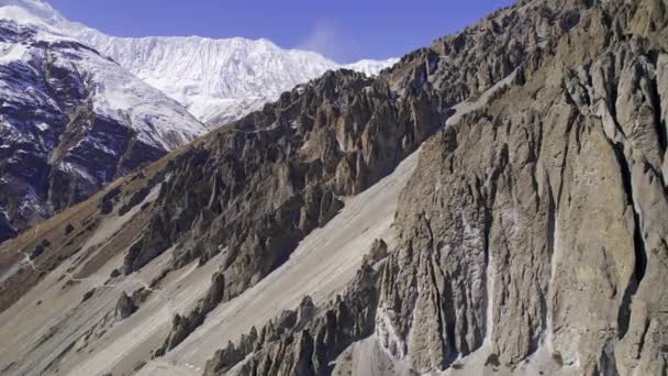 Flying Steep Rugged Cliffs Manang Nepal Snow Capped Mountains Distance — Vídeo de Stock