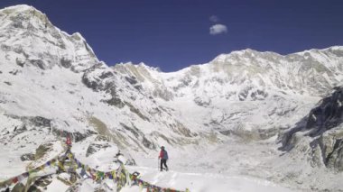 Nepal 'deki yürüyüş direklerini kullanarak Annapurna pistinde kar yürüyüşü yapan bir adam..
