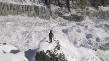 Nepal 'deki yürüyüş direklerini kullanarak Annapurna pistinde kar yürüyüşü yapan bir adam..