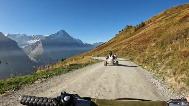 グリンデルヴァルト スイスのトレイルに乗るゴーカートに続く人々 — ストック動画