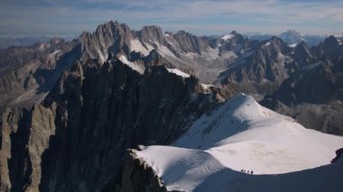 Aiguille du Midi 'den Mont Blanc aralığında karlı sırtta yürüyüş yapan insanların görüntüsü.
