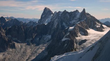 Aiguille du Midi 'den kar yamacına inen insanlar İsviçre' nin Mont Blanc bölgesindeki engebeli dağları görüyorlar..