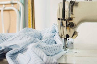 close up of sewing process with an old electronic sewing machine and a cotton cloth, with copy space, sewing and textile concept.