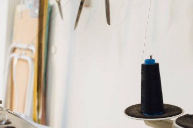 close up of roll of black thread on a sewing machine, copy space.