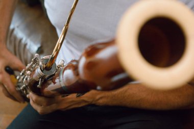 Evde fagot çalan tanınmayan Latin adamın yakın çekimi, boyun, ağızlık, müzik konsepti, kopyalama alanı üzerine odaklan.