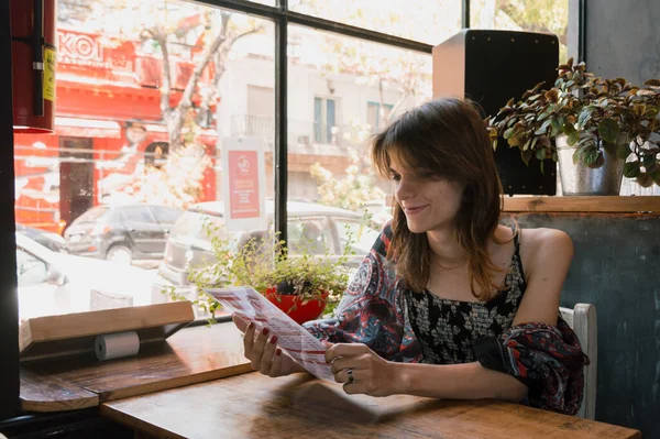 Genç transgender Arjantinli etnik Latin kadın restoran menüsünü okuyarak ne yiyeceğine karar veriyor. yiyecek kavramı, kopyalama alanı.