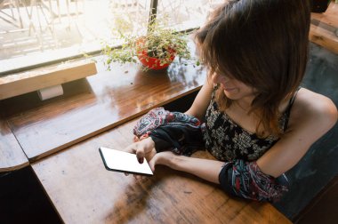 Transseksüel Arjantinli etnik kökenli Latin bir kadın restoranda telefon kullanıyor, masaya yaslanıyor, teknoloji kavramı, kopyalama alanı.