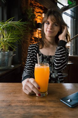 dikey portre genç Latin Latin transseksüel kadın Arjantin kökenli, restoranda oturuyor, kameraya bakıyor..