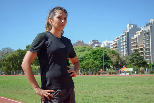 年轻的阿根廷裔女运动员 站在跑道上 手挽腰 沉着冷静地想着自己的训练 — 图库照片