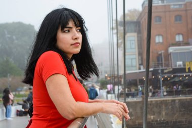 Puerto Madero 'daki genç Venezuelalı Latin turistin el Puente De La Mujer' de durup şehir manzarasını seyrederken, düşünürken, bulutlu bir günde, mekanı kopyalarken,.