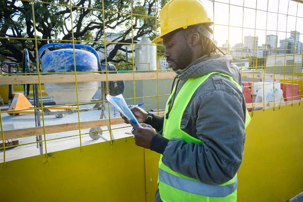 Sarı Kasklı Uzun Ceketli Genç Inşaat Mühendisi Gün Batımında Elinde — Stok fotoğraf