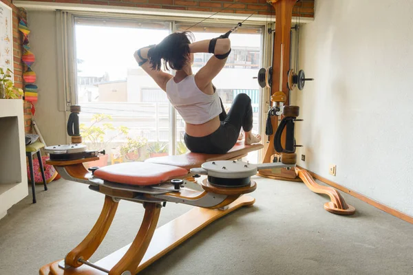 在家做腹部锻炼和加强背部锻炼的成年妇女 配有重型机械和滑轮 健康的生活理念 抄袭空间 — 图库照片