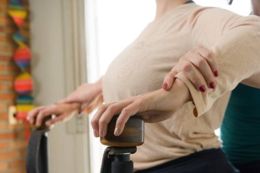 Öğrencisine jirotonik makine kullanmasında rehberlik eden, evde oturup eklem egzersizleri yapan ve eklemlerini güçlendiren Kafkas hocasının yakın çekimi..