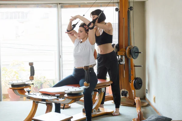 两名高加索成年妇女在家里与旋转机械一起训练 健康概念 复制空间 — 图库照片