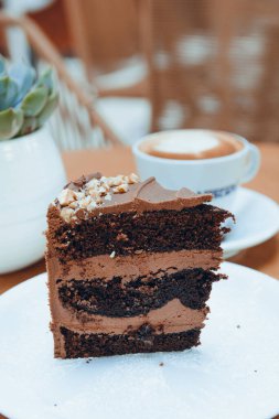 Tabakta servis edilen çikolatalı pastanın porsiyonu kafede bir fincan kahvenin yanında sosyal ağlar için hamur işi konsepti, fotokopi alanı..