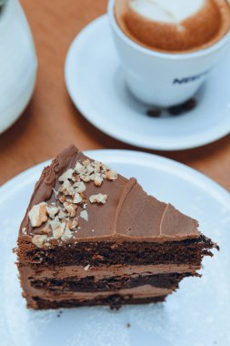 Tabakta servis edilen çikolatalı pastanın porsiyonu kafede bir fincan kahvenin yanında sosyal ağlar için hamur işi konsepti, fotokopi alanı..