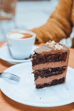 Kafe ve pasta konseptinin sosyal ağları için kek yiyip kahve içen tanınmamış bir kadının dikey görüntüsü