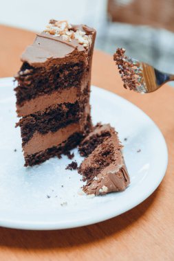 Beyaz porselen tabakta servis edilen beyaz porselen pasta dilimiyle kesilen beyaz beyaz beyaz beyaz beyaz beyaz kadının el resmi, sosyal medya için hamur işi kavramı, kopyalama alanı