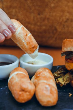 Kafkas kadın eli, tanınmayan bir kadının mayonez, ketçap ve Venezuela fast food konseptiyle tekeno yediği yakın plan.